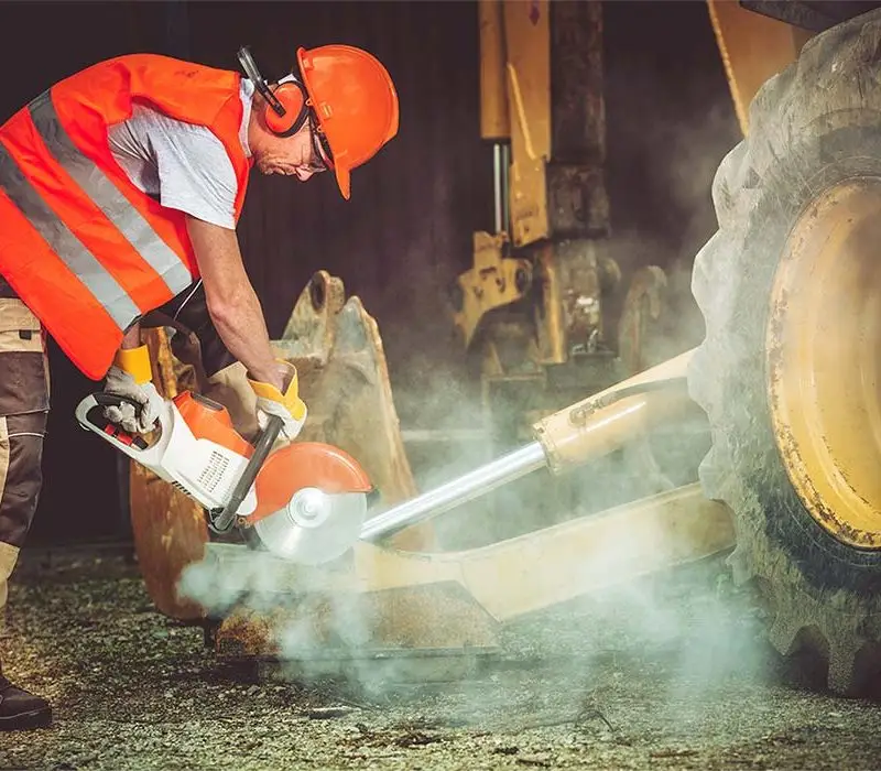 HOME 2 Excavation,demolition,trenching,Grading,Land clearing,Concrete removal,rock wall,canal reconstruction,patio pavers,excavation contractors Construction worker cutting materials with a Stihl cut-off saw on a worksite.