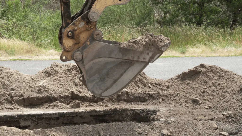 EXCAVATION 1 excavation Close-up view of excavator bucket digging soil at a construction site.