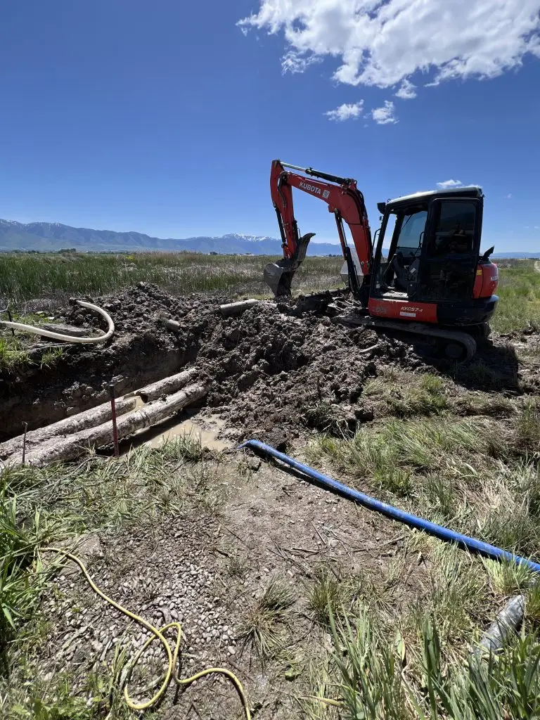 Trenching on farmland with an excavator for agricultural main line installation